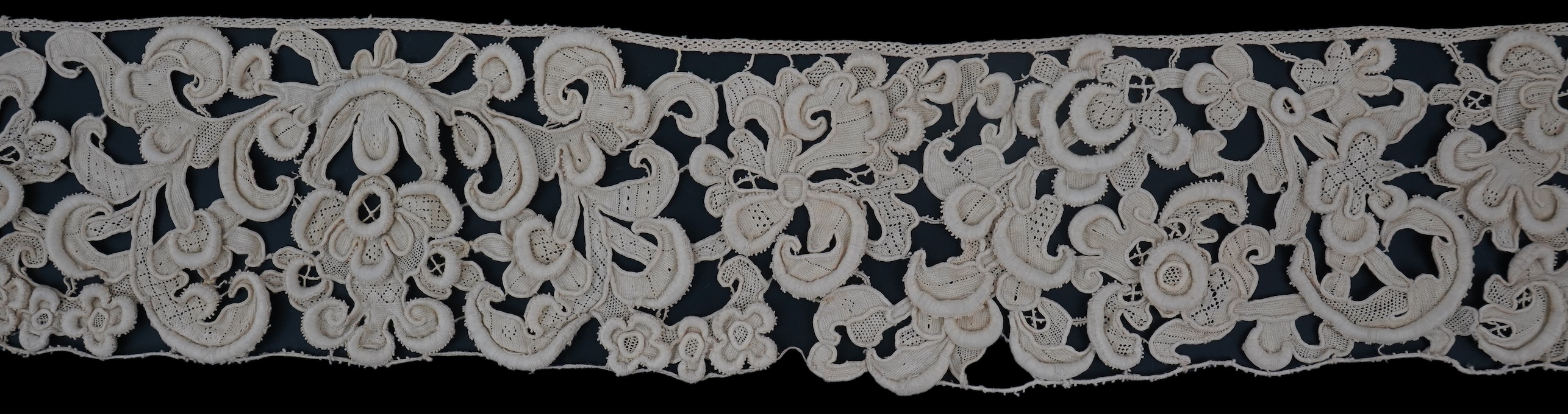 A length of 1660-1670 Italian Venetian Gros Point needle lace, this heavy needle lace was made with a wide cordonnet padded with wool, using close buttonhole stitch, to create large scrolling patterns in heavy relief, li